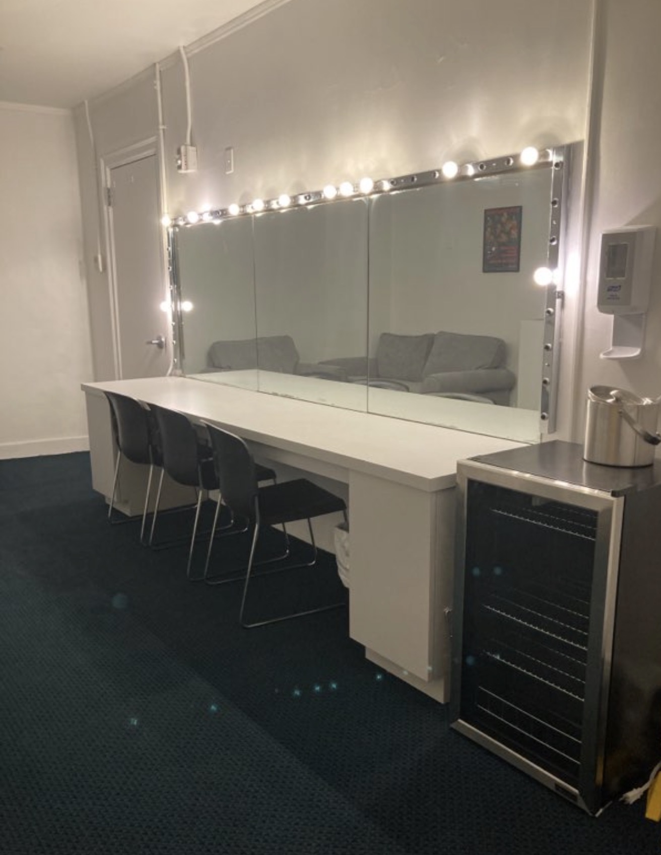 Dressing room illuminated mirror station with chairs and refreshment cooler